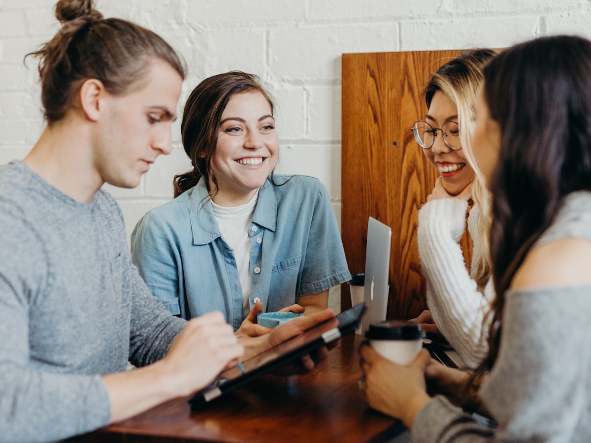 Small group gathered around a table, engaged and smiling in an informal setting