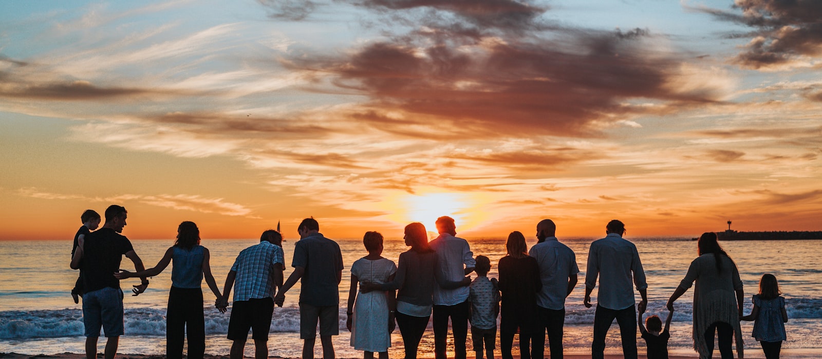 Multiple families gathered together on the beach at sunset